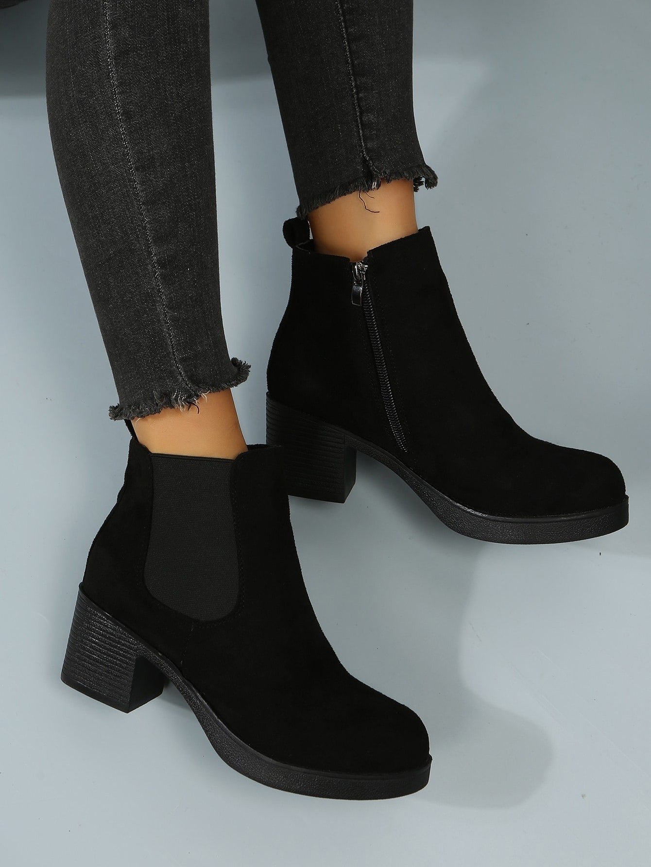 بوت تشيلسي ذات كعب سميك مزودة بسحاب، بوت نسائية ذات لون أسود أنيق وصلب ، ذات كعب عالي، تُرتدى مع البنطلونات والسراويل الضيقة ذات طابع أنيق
