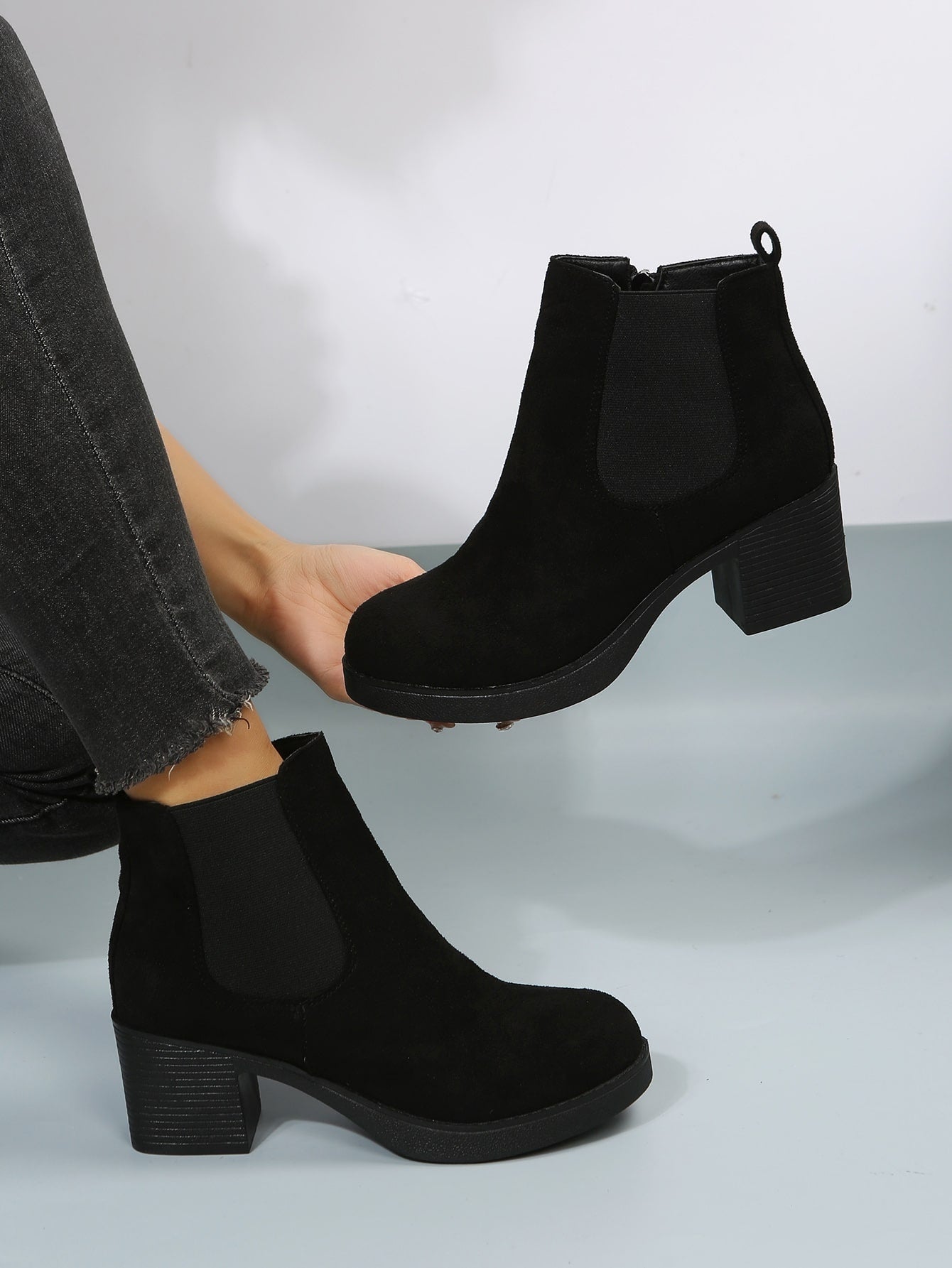 بوت تشيلسي ذات كعب سميك مزودة بسحاب، بوت نسائية ذات لون أسود أنيق وصلب ، ذات كعب عالي، تُرتدى مع البنطلونات والسراويل الضيقة ذات طابع أنيق