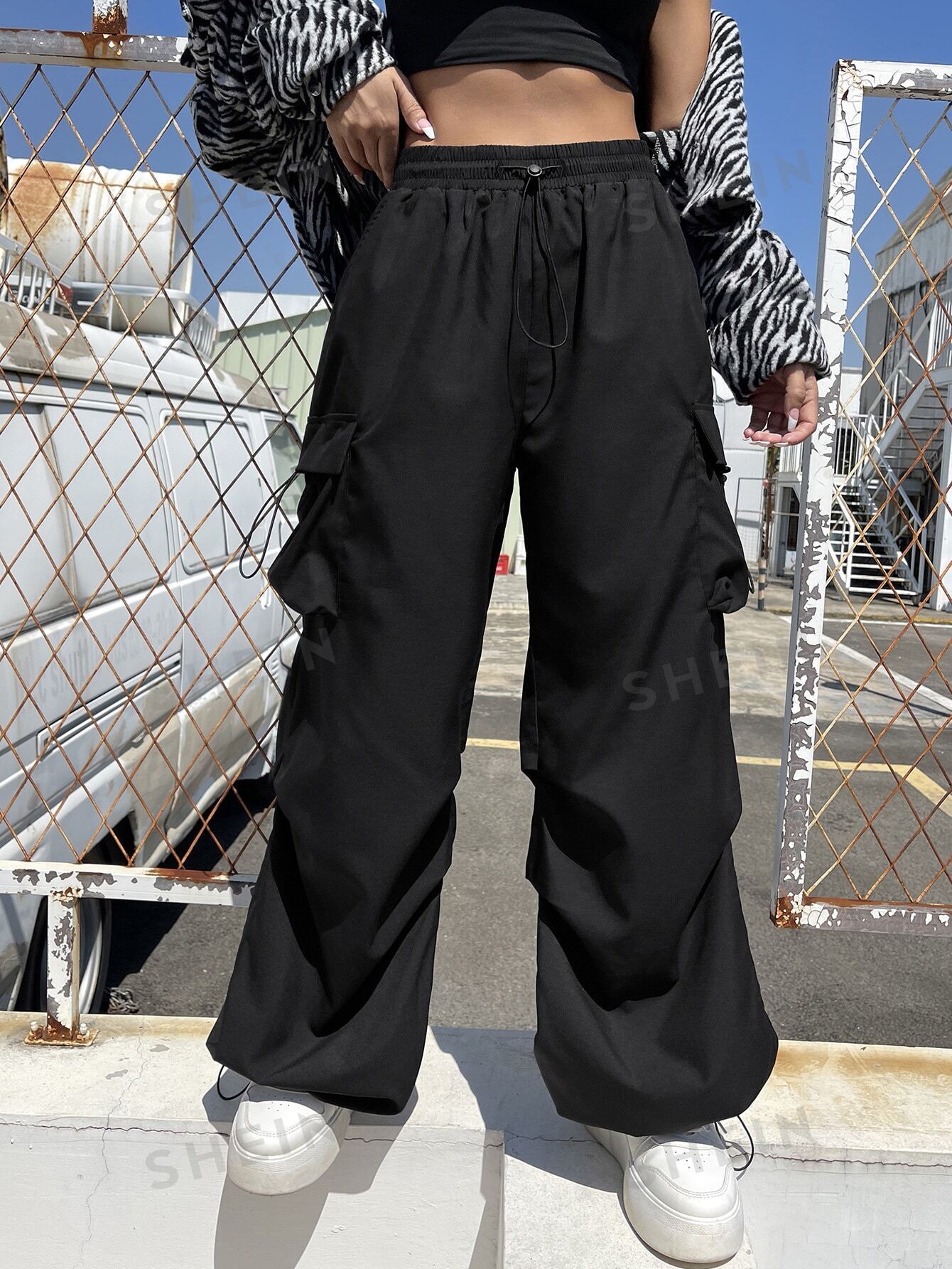 سروال باراشوت الرياضي سوداء اللون بجيوب يلتف بالكتف للنساء، ملابس رياضية للشارع و الرياضة مع أربطة جانبية عند الخصر