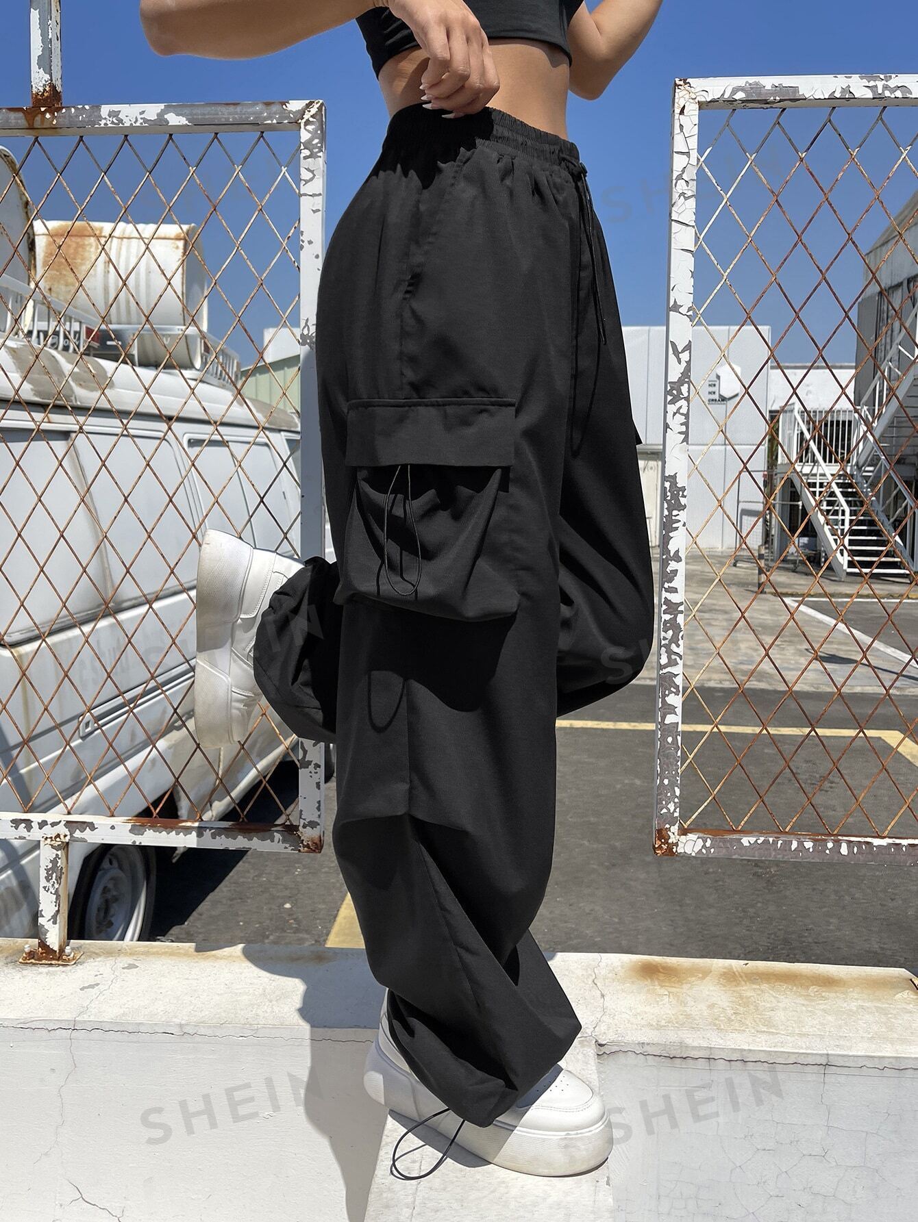 سروال باراشوت الرياضي سوداء اللون بجيوب يلتف بالكتف للنساء، ملابس رياضية للشارع و الرياضة مع أربطة جانبية عند الخصر