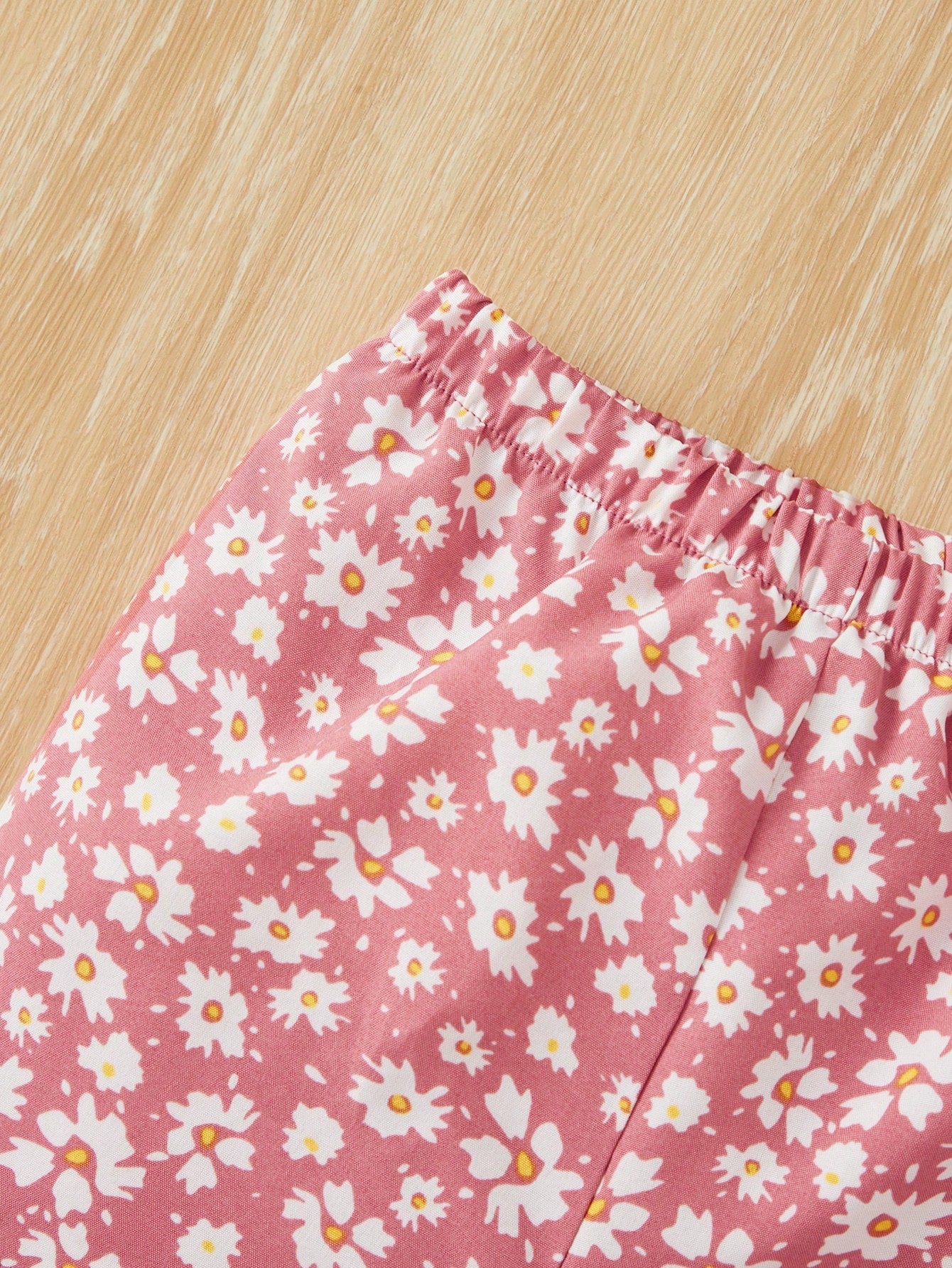 بدلة صبيّة عارضة من قطعتين مكونة من تي شيرت قصّة قصيرة بياقة مزيّنة بالرّوبيّات ذات خصر مطاطيّ وشورت زهري مناسبة لفصل الصيف