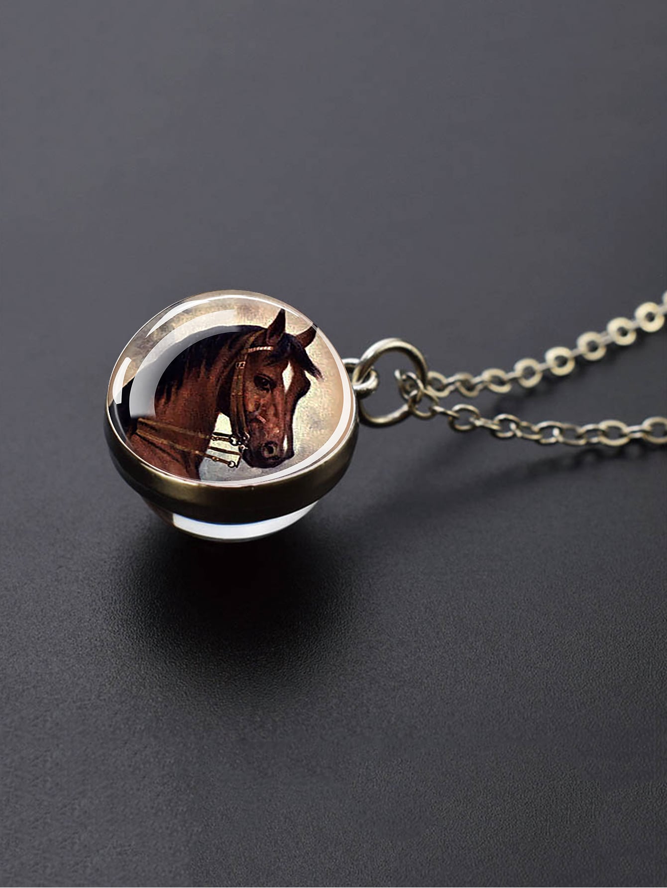 قلادة على شكل نصف كرة زجاجية ورأس حصان