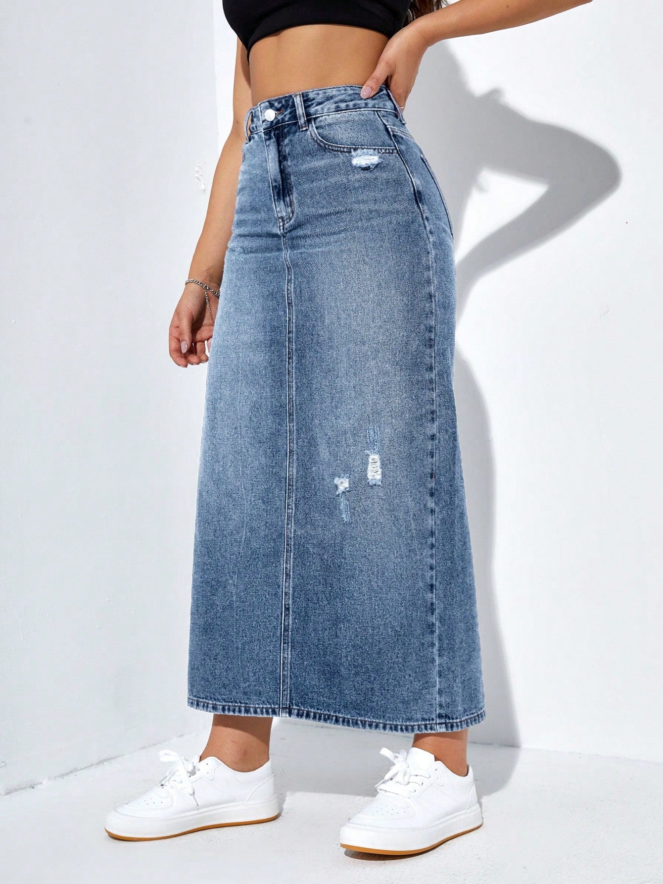 تنورة جينز طويلة بتفاصيل متهالكة وشق في الحاشية