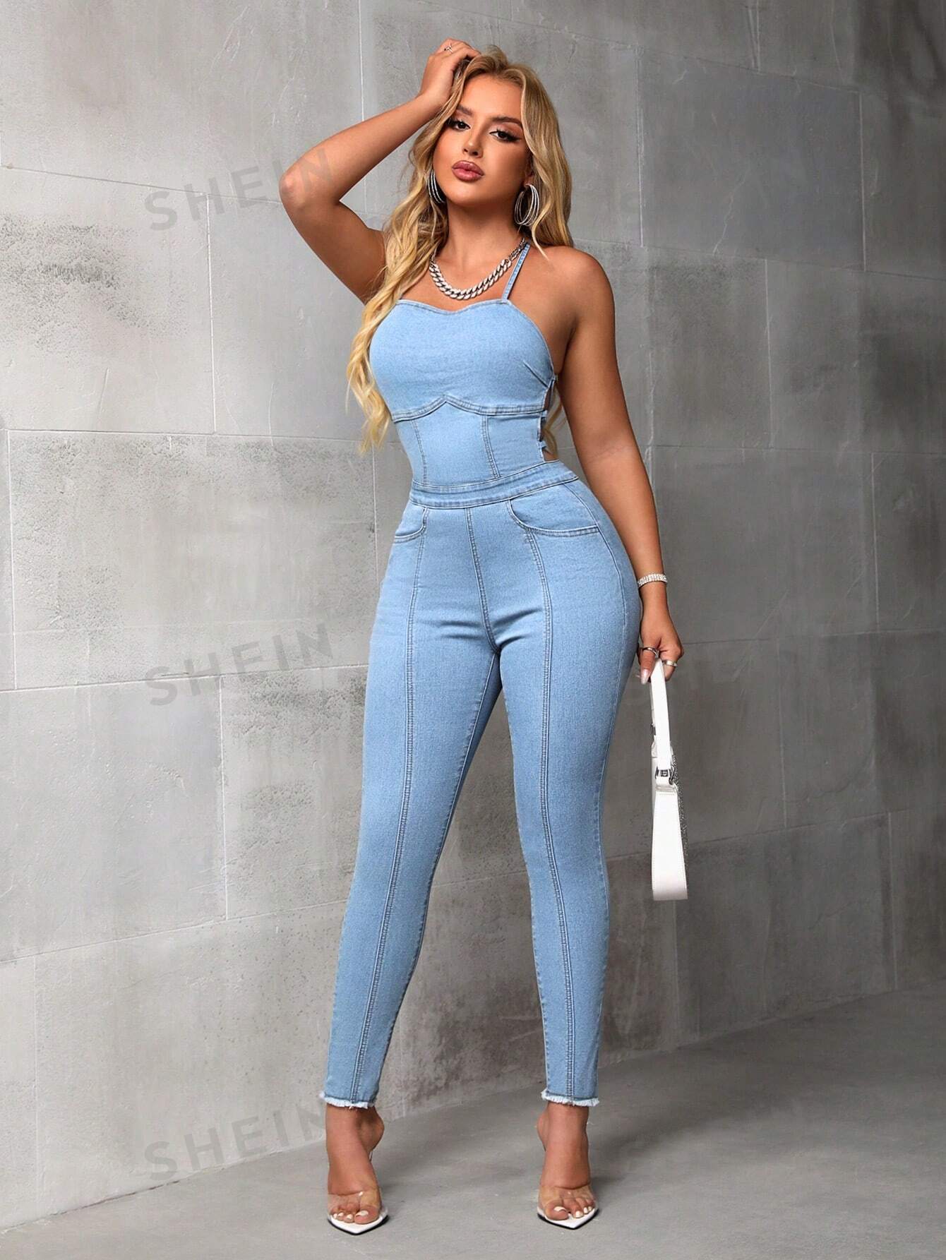 بدلة جينز ضيقة مع حمالات وتفاصيل مفرغة