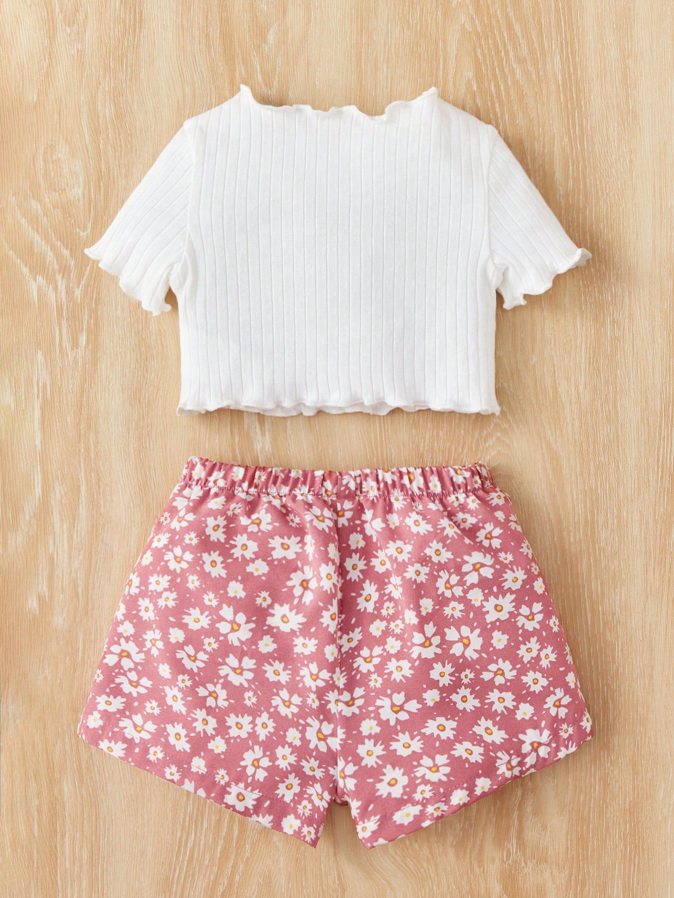 بدلة صبيّة عارضة من قطعتين مكونة من تي شيرت قصّة قصيرة بياقة مزيّنة بالرّوبيّات ذات خصر مطاطيّ وشورت زهري مناسبة لفصل الصيف