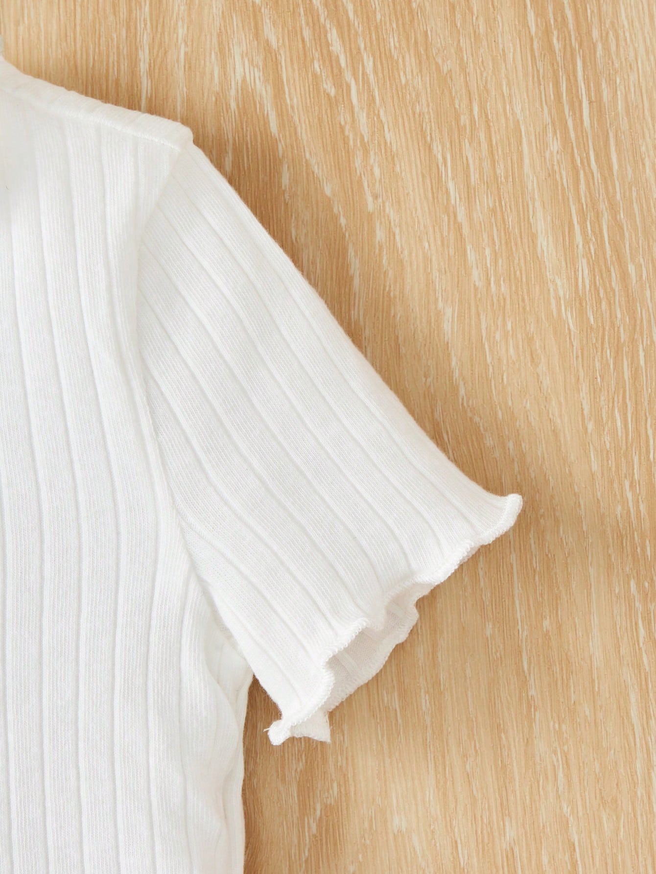 بدلة صبيّة عارضة من قطعتين مكونة من تي شيرت قصّة قصيرة بياقة مزيّنة بالرّوبيّات ذات خصر مطاطيّ وشورت زهري مناسبة لفصل الصيف