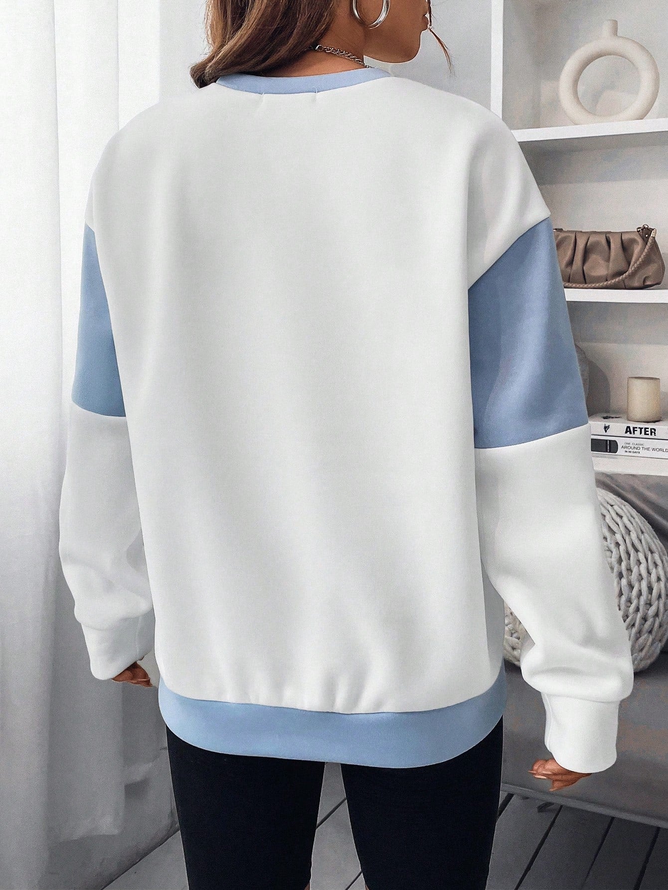 بلوفر رياضي ذو أكتاف متساقطة عليه رسمة حرفية