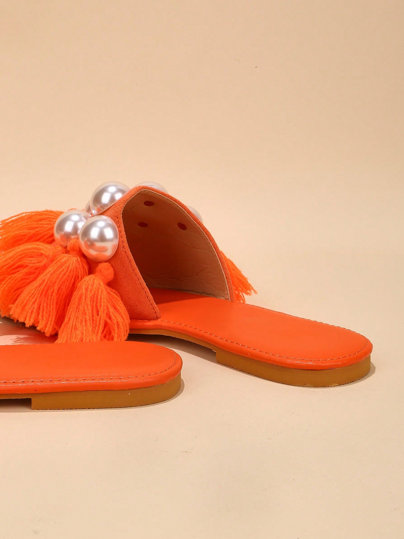 حذاء رملي مسطح مرصع باللؤلؤ والزينة ونعل شفاف يعتبر موضة