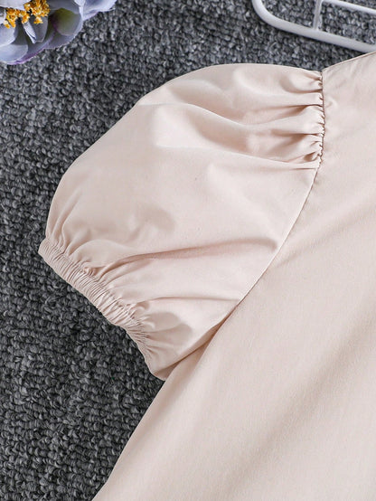 فستان قصير ذو أكمام قصيرة ورقبة دائرية وتصميم مربعات مرح وعصري. تناسب الفتيات الصغيرات، مزود بعقدة أنيقة ومناسبة لفصل الصيف