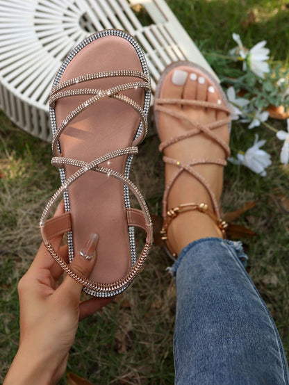 صنادل مسطحة برأس مدور وتفاصيل معدنية ومرصعة بالراين، حزام كاحل مطاطي، استيل روماني للنساء