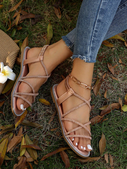 صنادل مسطحة برأس مدور وتفاصيل معدنية ومرصعة بالراين، حزام كاحل مطاطي، استيل روماني للنساء