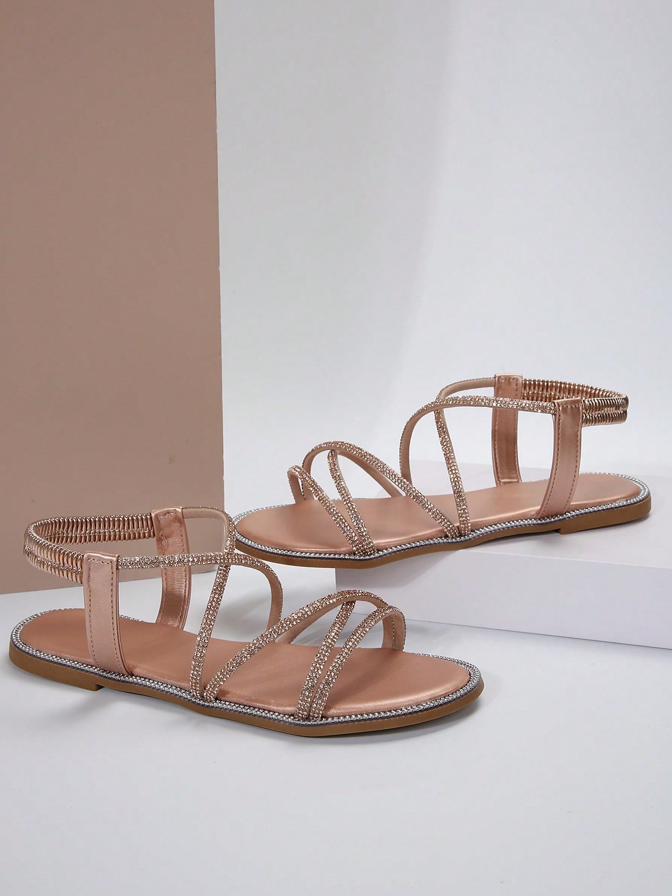 صنادل مسطحة برأس مدور وتفاصيل معدنية ومرصعة بالراين، حزام كاحل مطاطي، استيل روماني للنساء