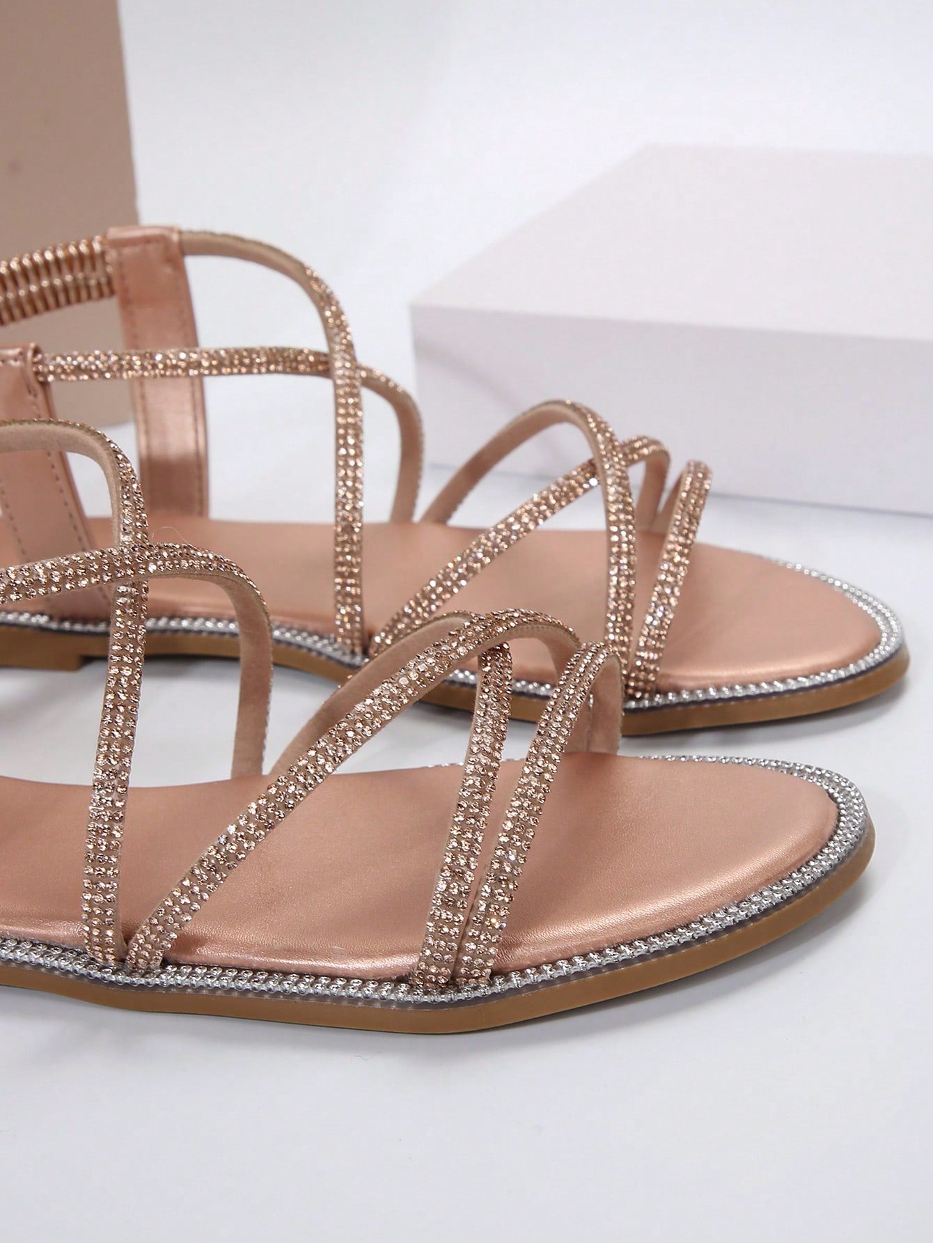 صنادل مسطحة برأس مدور وتفاصيل معدنية ومرصعة بالراين، حزام كاحل مطاطي، استيل روماني للنساء