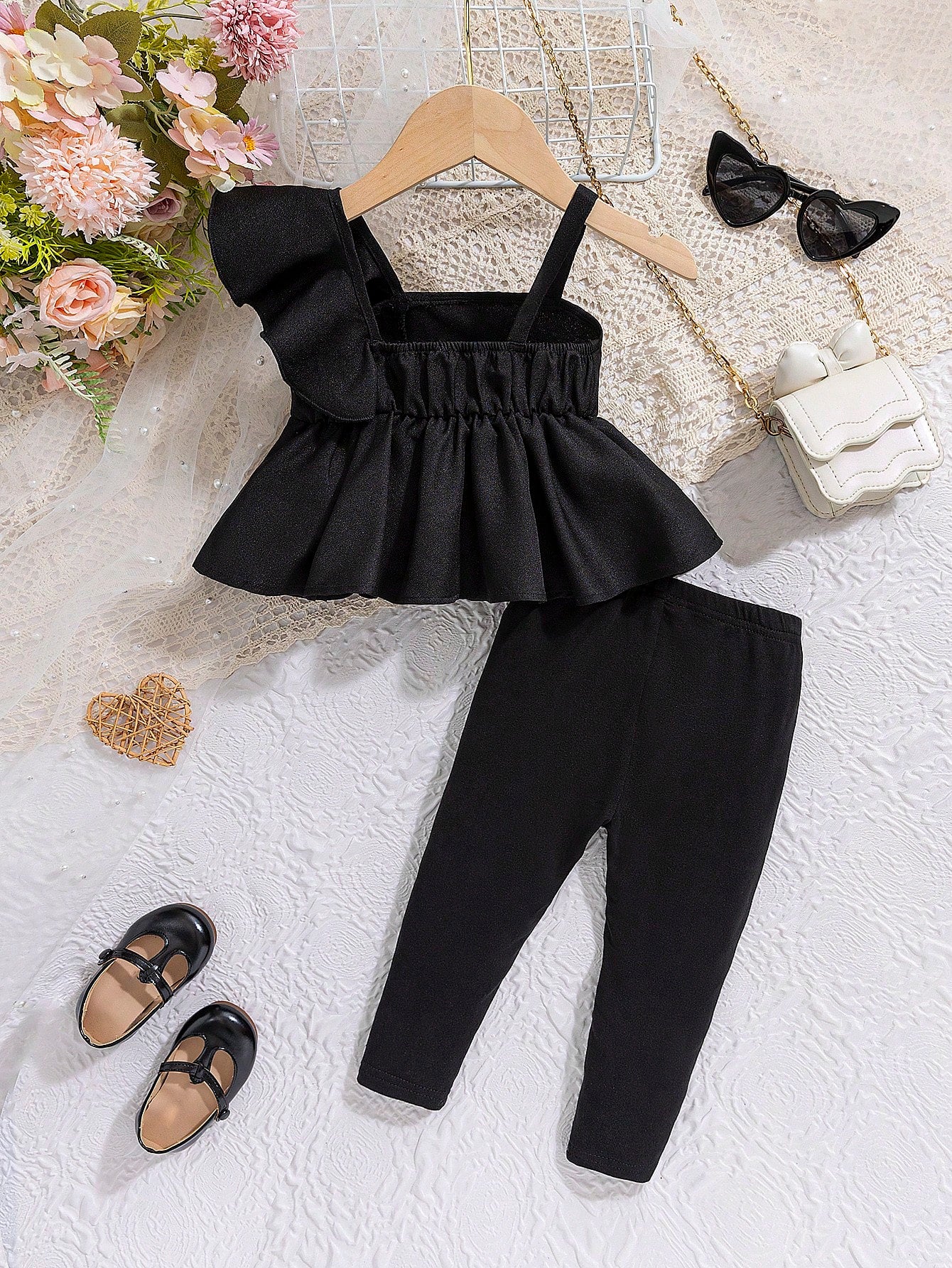 بدلة صيفية عارضة للرضع الإناث ، تضمن أحزمة كتف رقيقة ومتموجة، وقميص بلا أكمام، وسروال طويل ضيق مع خصر مرن مصنوع من الوان صلبة مما يجعلها مناسبة لفصل الصيف.