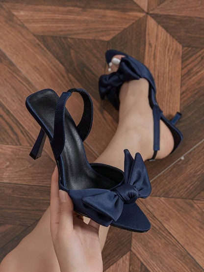 صنادل ذات كعب عالي مزينة بفراشة وحزام مطّاطي