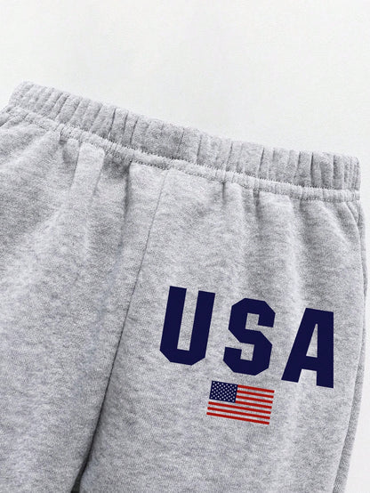 بدلة ملابس تتكون من بلوزة رياضية ذات رقبة طاقم مع طباعة أحرف، وبنطلون رياضي للأطفال الصغار